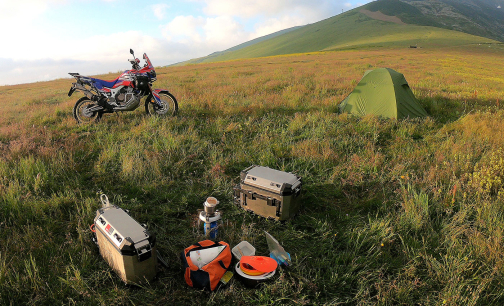 On a motorcycle, from the saddle… to the tent